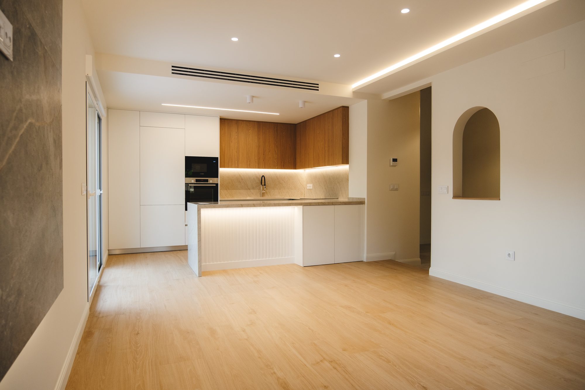 Salón con cocina al fondo y foseado de luz