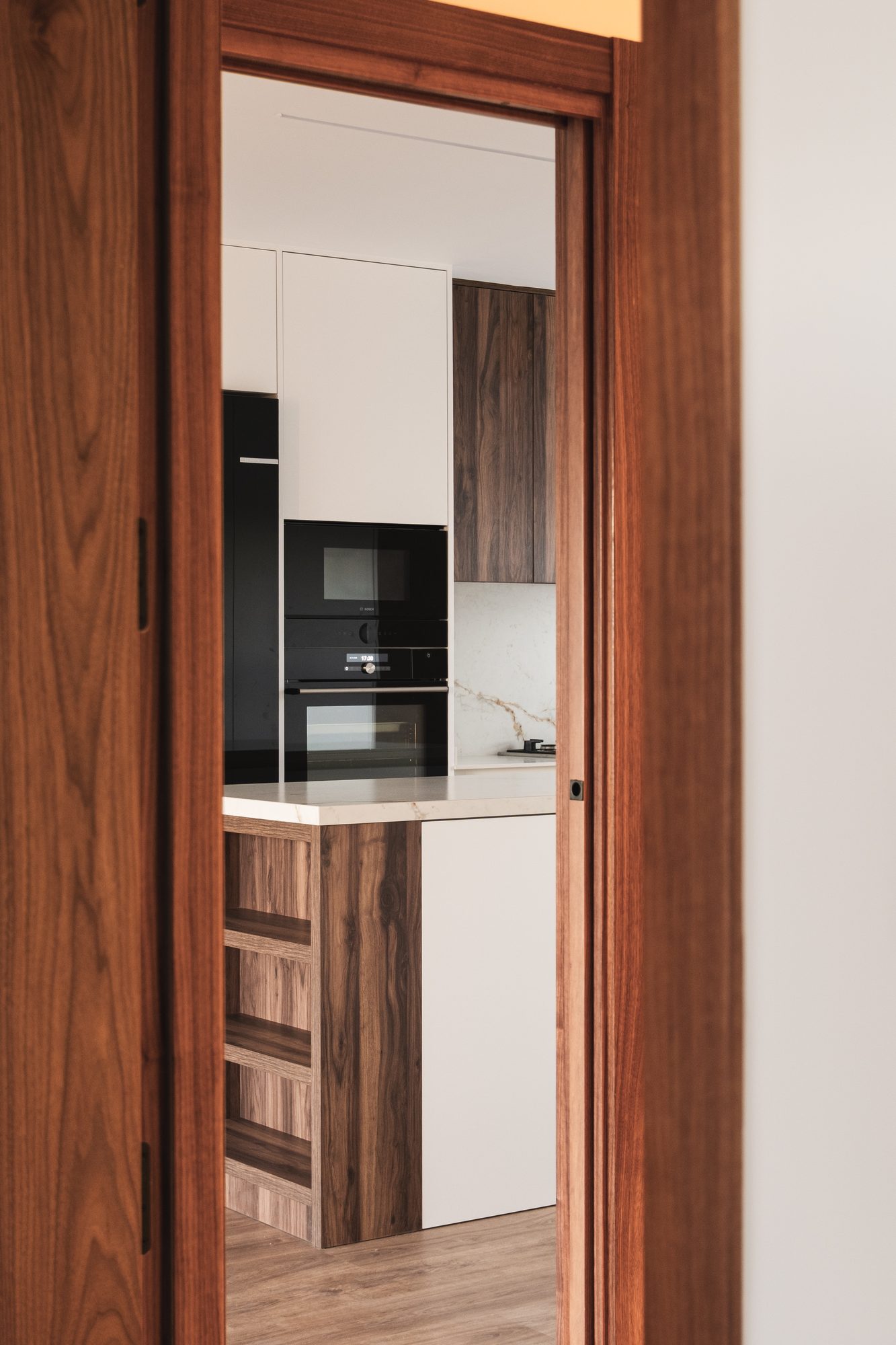 Cocina vista a través de una puerta de nogal